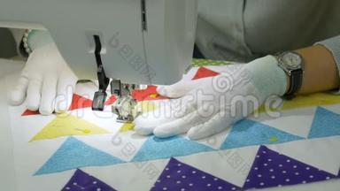 在缝纫机上工作。 一个戴白色手套的女人在织物上涂鸦。